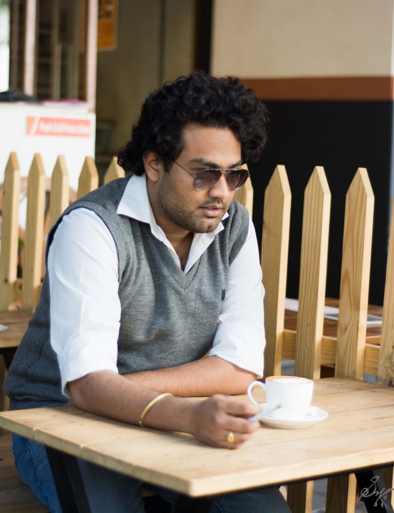 Man sitting in a coffee shop with cigarette in hand thinking about past