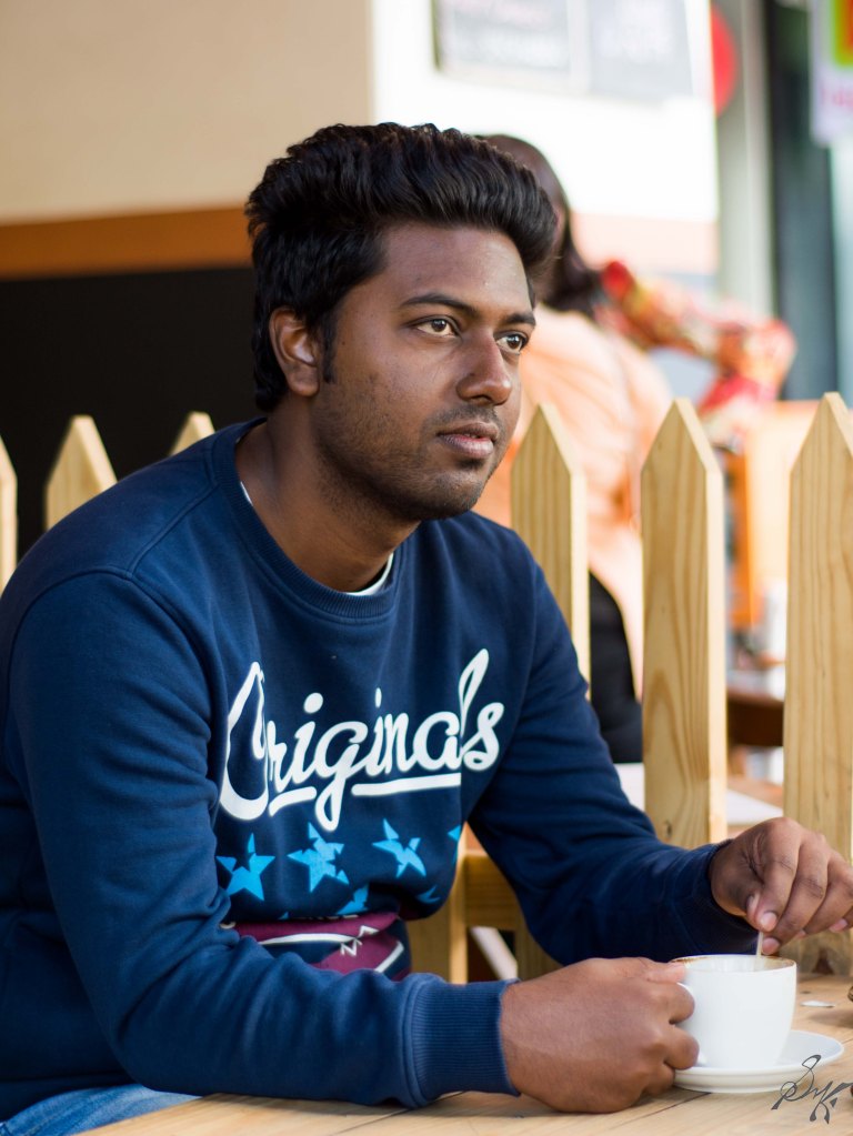 Man stirring a cup of coffee looking forward to the future