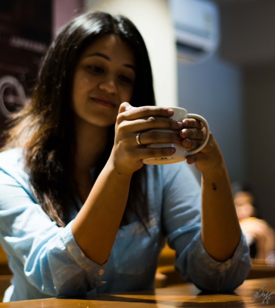 Woman with a cup of coffee with focus on engagement ring