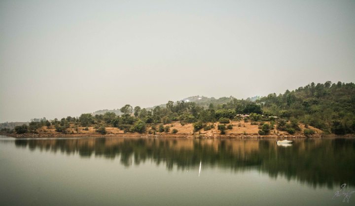 Long exposure photo of lake with landscapes mirrored into the lake. Long exposure photo of lake with landscapes mirrored into the lake.