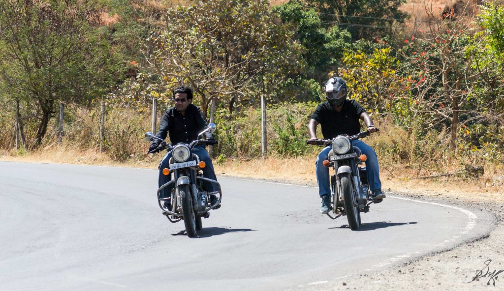 Two men on Royal Enfield Bullet taking a turn