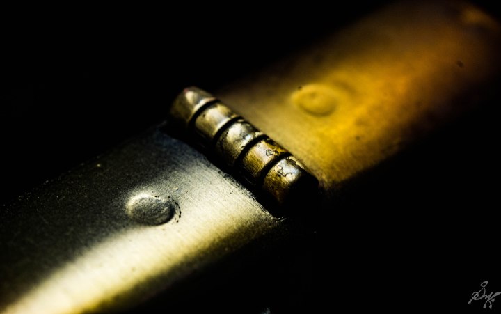 macro close up of the hinge of a zippo lighter