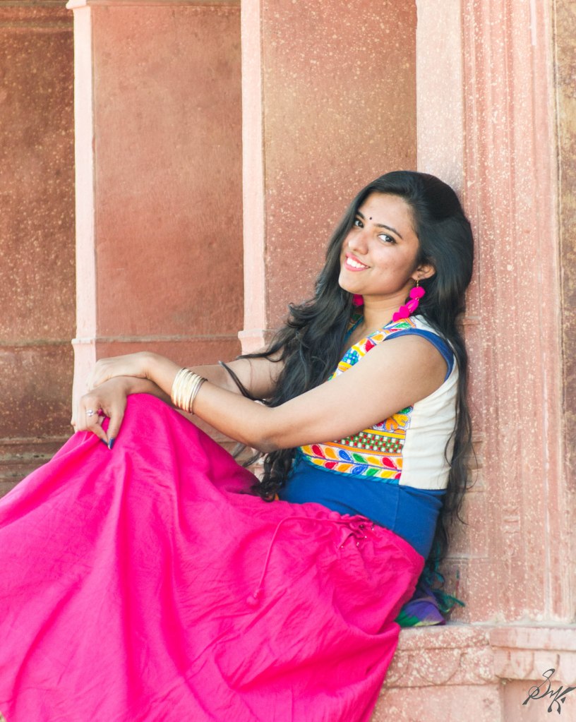 Girl sitting and smiling at cenotaph of Musi Maharani, City Palace, Alwar, Rajasthan