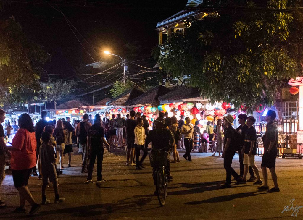 Busy street with tourists and locals, lights, food, Hoi An, Vietnam