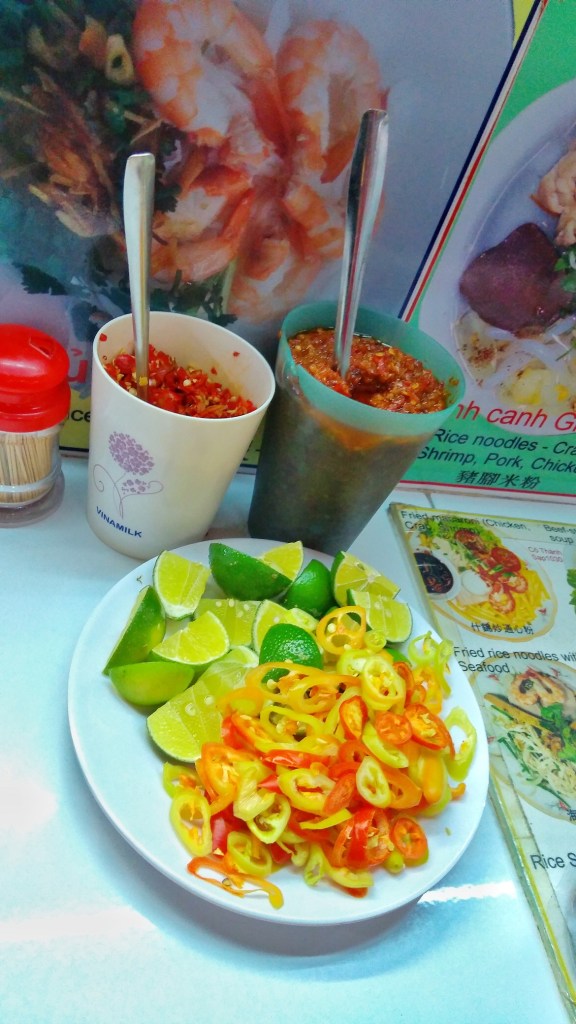 Condiments accompanying Banh Mi , chilly, sauce, lemon