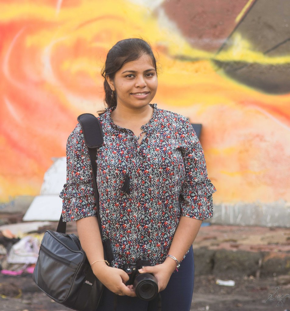 Haldar posing in front of a wall art, Sassoon Docks, Mumbai, India